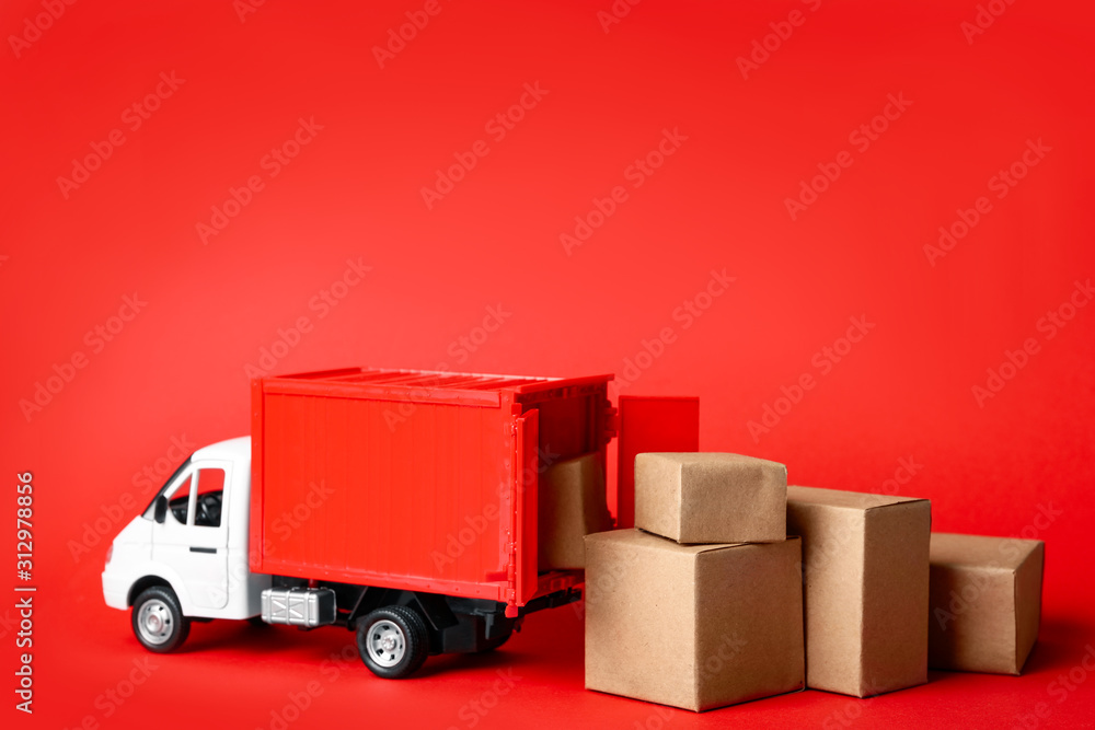 Toy truck with boxes on red background Logistics and wholesale concept - obrazy, fototapety, plakaty 