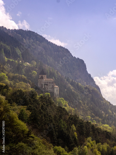 fortress on a steep mountainside. forest mountains