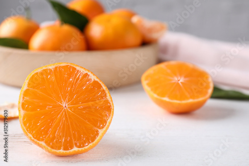 Cut fresh ripe tangerines on white wooden table