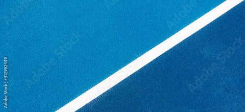 Colorful sports court background. Top view light blue and navy blue field rubber ground with white line outdoors © vejaa