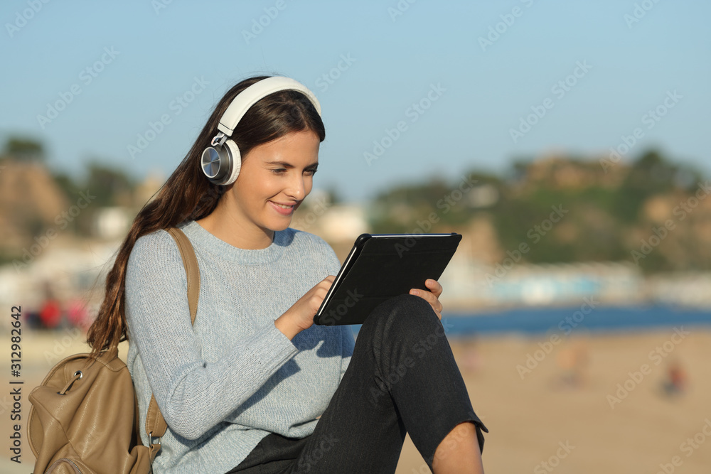 Happy girl e-learning using tablet and headphones