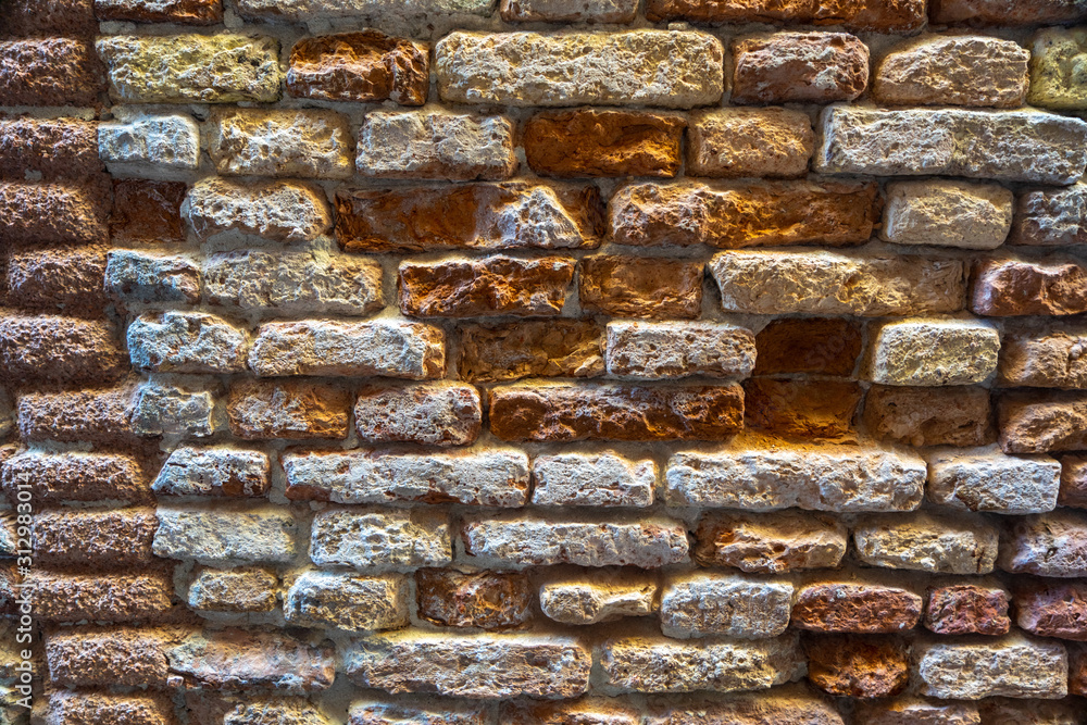 Old textured destroyed brickwork of a wall closeup.