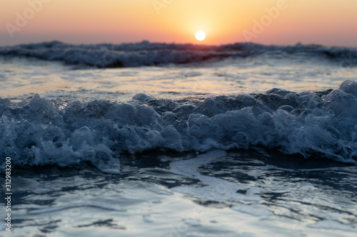 Waves of the Mediterranean Sea with sea foam and spray. Beautiful sea on sunset background. Sundown. Seascape.
