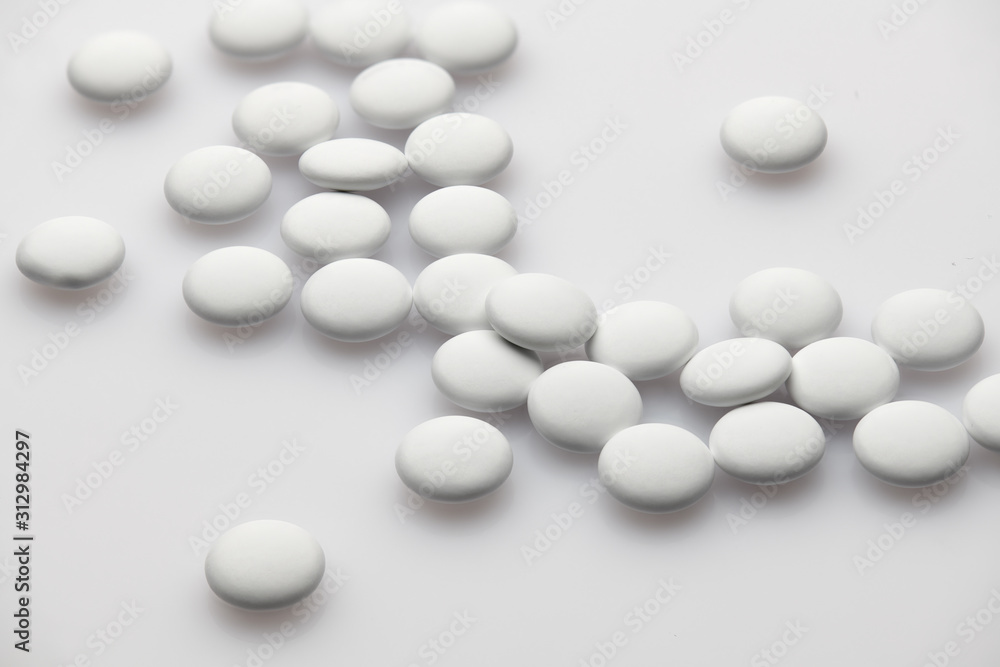 Group of white pills on white background - healthcare and medicament concept. Pharmaceutical industry. Pharmacy. Group of white pills on white background - healthcare and medicament concept. Pharmaceutical industry. Pharmacy.