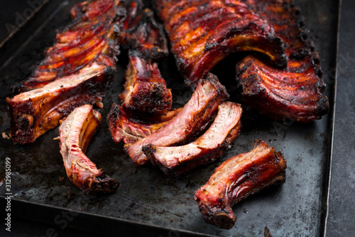 Barbecue pork spare ribs St Louis cut with hot honey chili marinade as closeup on an old rustic metal board