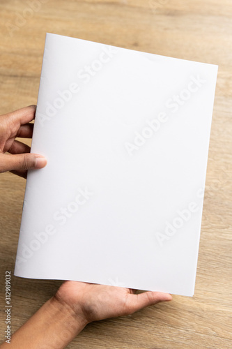 Ethnic model holding an A5 or half letter sized brochure  © TheCreativeBrigade
