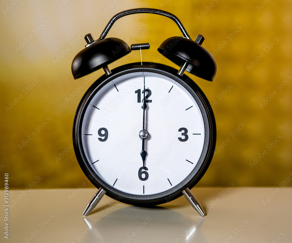Alarm clock with simple and minimalistic design. Arrows pointing at 6 am.  Stock Photo | Adobe Stock