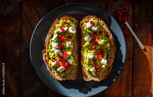 Avocado sandwich on sliced bread toast made with pomegranate and feta cheese