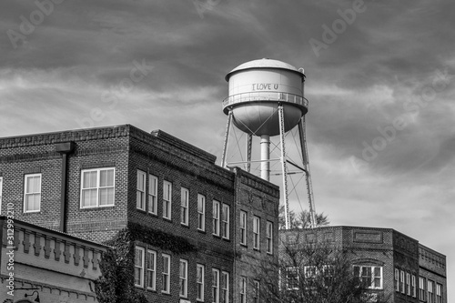 Water tower over brick buildings in monochrome