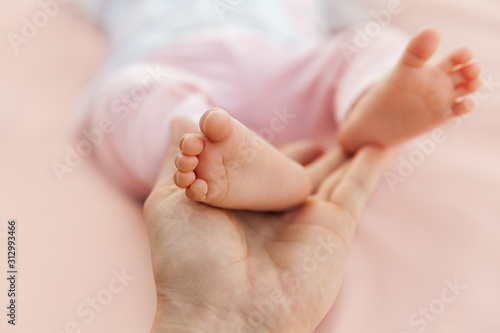 Mother holding newborn baby girl feet, closeup of barefoot © photobyevgeniya