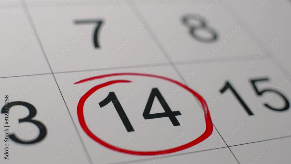 Signing a day on a calendar by red pen, fourteenth of february Valentine's day. Valentine's Day concept. Signing a day on a calendar by red pen, fourteenth of february Valentine's day. Valentine's Day concept.