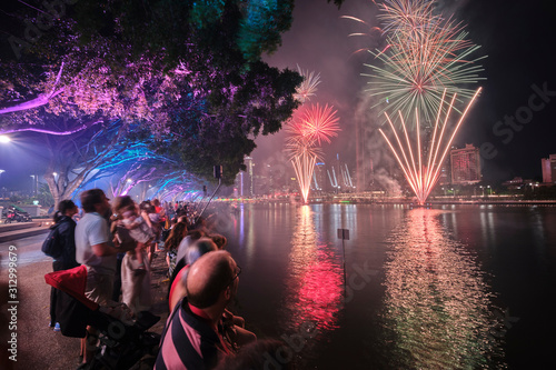 Brisbane Christmas fireworks with colourful trees and people lining the banks of the Brisbane River at Southbank