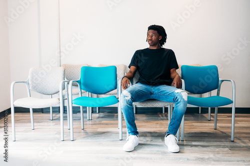 Gen Z boy sitting in doctors wait area