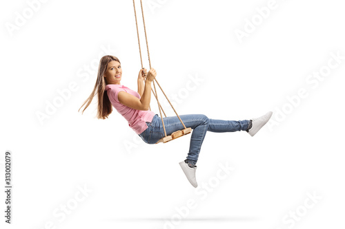 Young woman with long hair swinging on a wooden swing