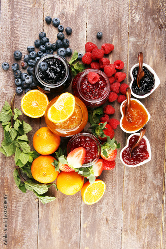 Fototapeta Naklejka Na Ścianę i Meble -  assortment of jams, seasonal berries jelly, mint and fruits and tangerine