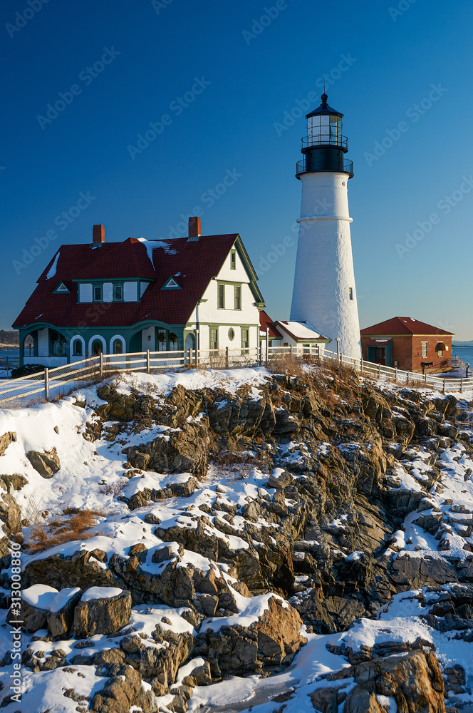 World famous Portland Head Lighthouse on the Maine coast sits under a blanket of snow as it protects the shipping lanes into Casco Harbor