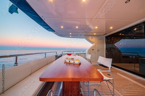 Beautiful shot from the yacht of wine glasses and snacks on the wooden table © SPIX PRODUCTION