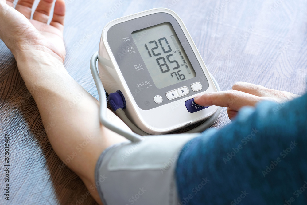 Man check blood pressure monitor and heart rate monitor with digital pressure gauge. Health care and Medical concept Man check blood pressure monitor and heart rate monitor with digital pressure gauge. Health care and Medical concept