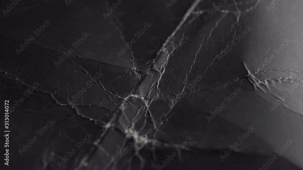 Old black wrinkled paper with scuffs and wrinkles. Slow Track Camera. Abstract background Old black wrinkled paper with scuffs and wrinkles. Slow Track Camera. Abstract background