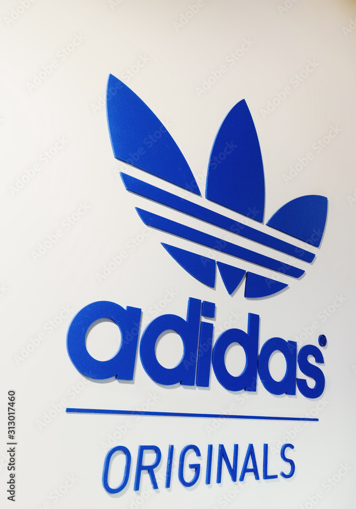 Adidas Originals logotype on white wall Stock Photo | Adobe Stock