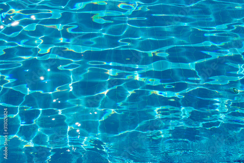 Blue bottom through the transparent water with sunspots of light in the pool © oksmit