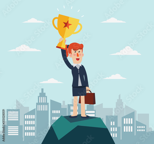 Successful, smiling, young, happy business woman standing on a top of a mountain and holding up winning trophy