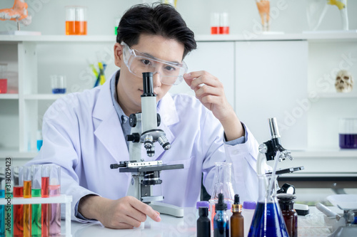 Fototapeta Naklejka Na Ścianę i Meble -  concept of medical, chemicals or scientific laboratory research and Innovation in the laboratory. experienced handsome Asian man scientist is performing work in the laboratory.