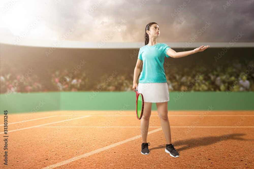 Asian tennis player woman with a tennis racket serving the ball
