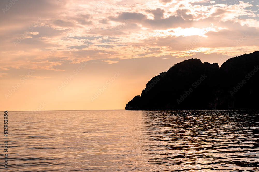 Dramatic Silhouette of mountains in the middle of andaman sea near Phi Phi Islands during sunset.