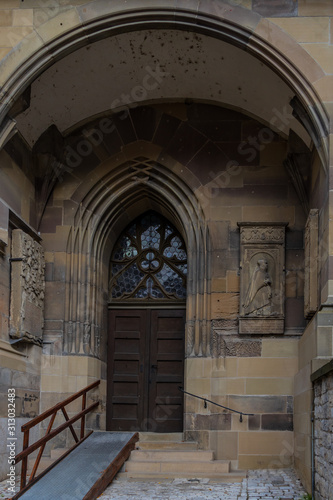 Rustic old wooden double door and stone arch entry