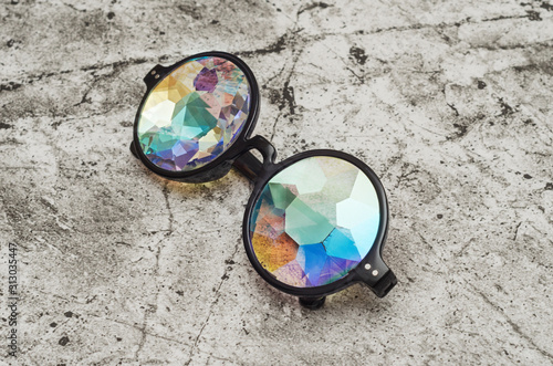 Designer glasses with lenses from a kaleidoscope on a gray abstract background