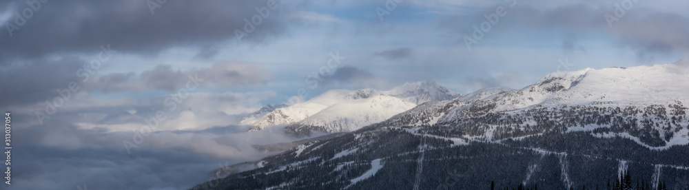 Whistler, British Columbia, Canada. Beautiful View of the Canadian Snow Covered Landscape with Blackcomb Mountain in Background during a cloudy and foggy winter day.