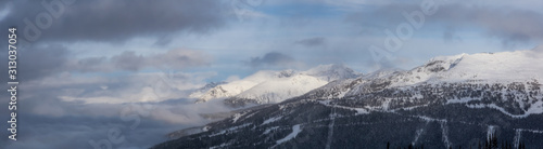 Whistler, British Columbia, Canada. Beautiful View of the Canadian Snow Covered Landscape with Blackcomb Mountain in Background during a cloudy and foggy winter day. © edb3_16