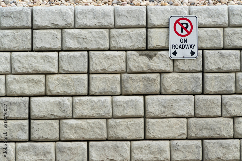 Retaining wall with no parking sign on it Retaining wall with no parking sign on it