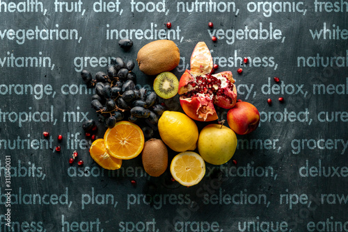 flat lay fresh fruit selectrion layout on a grunge surface such as grapes, kiwi, orange, exotic tropical fruitss photo