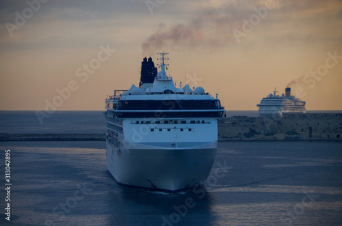 Cruise ship NCL Norwegian Spirit and Costa Magica arrival into port of Valletta on Malta in early morning during sunrise photo