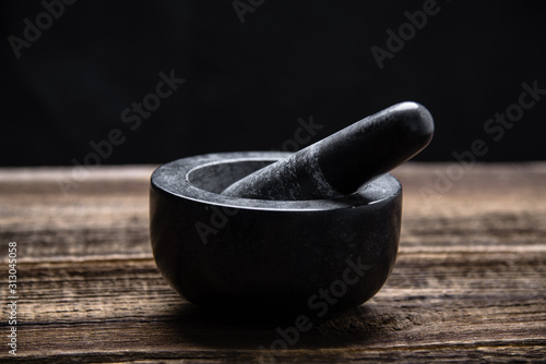 Obraz na plátně Pestle and mortar with black stone on wooden table