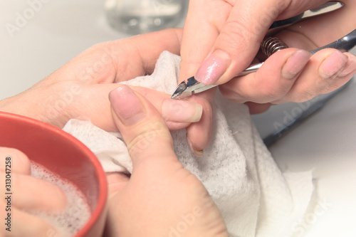 Nail Care Procedure. Nail salon, manicurist polishes a woman's nails.