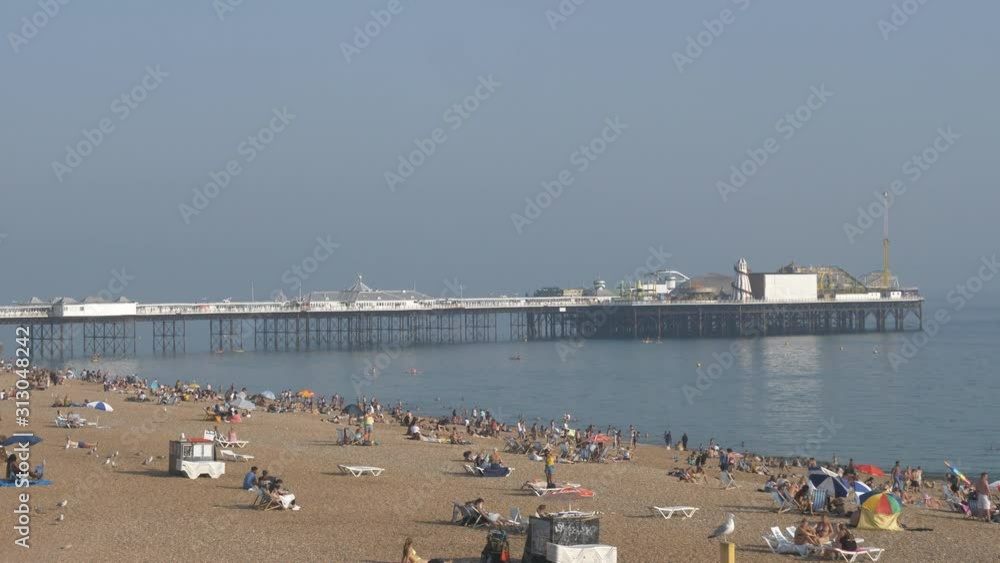 A Brighton pier and people on the beach. A Brighton pier and people on the beach.