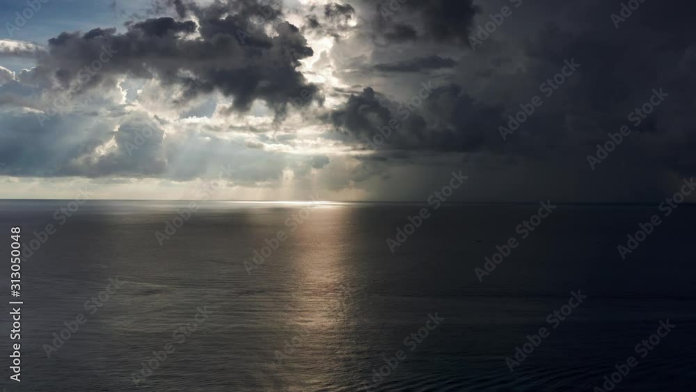 Aerial rising over ocean into beautiful sun spot and dark clouds, Roatan Aerial rising over ocean into beautiful sun spot and dark clouds, Roatan