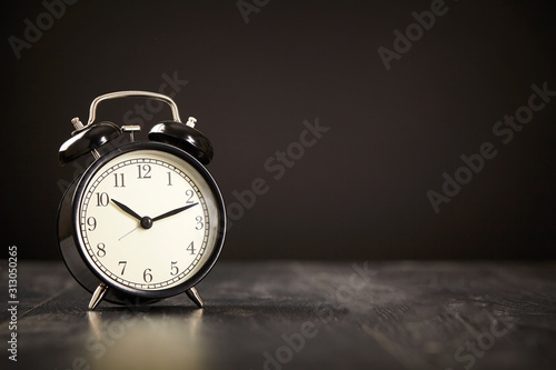 Alarm clock on a black background with copy space. Close up.