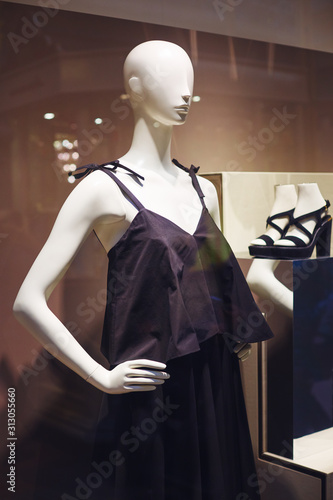 Mannequins standing in store window display of womens casual clothing shop in shopping mall