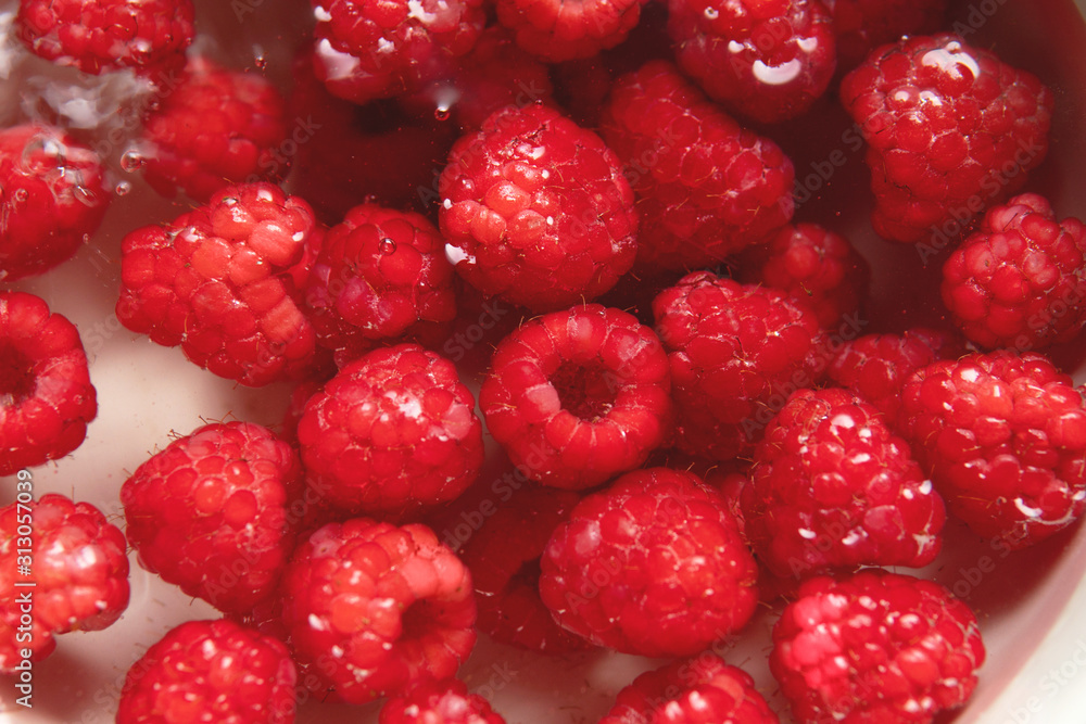 Close-up washing raspberries in a fresh water. Close-up washing raspberries in a fresh water.
