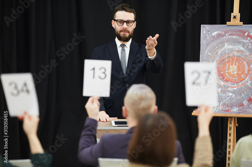 Slika na platnu Young businessman in suit standing and pointing at candidate who wants to buy a