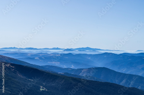 Mountain clean landscape for the background of the website landing page or booklet. Rocks and hills far in the horizon. Colored sky. © Payllik
