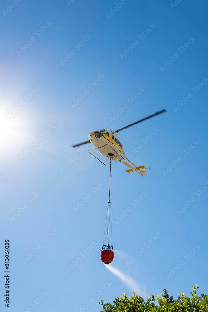 fire rescue helicopter carrying a water bucket no markings Stock