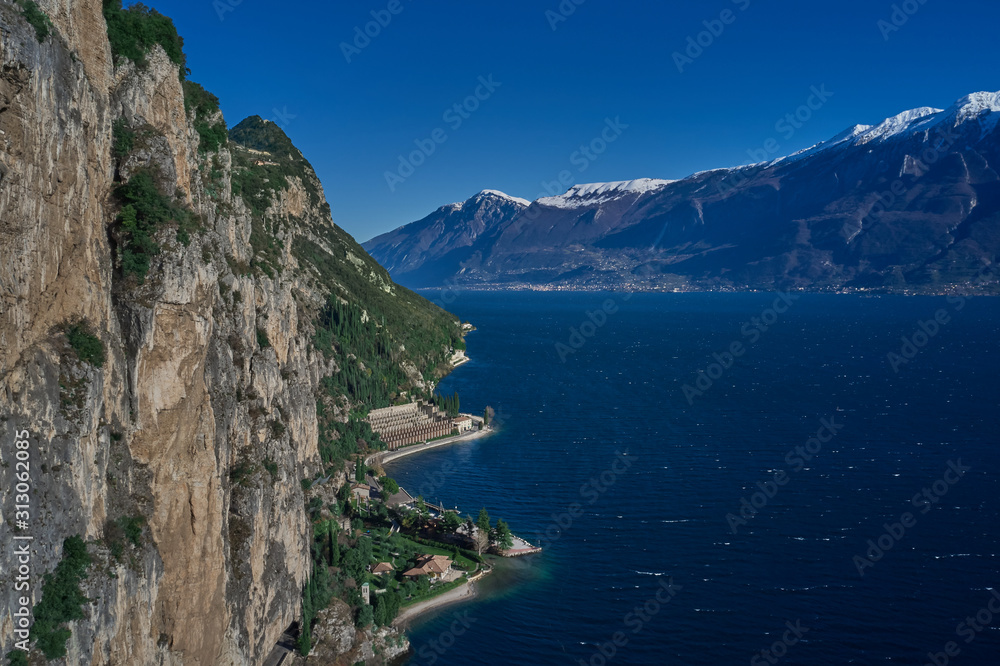 Rocks on Lake Garda, Italy aerial view. Mountain tops in the snow
