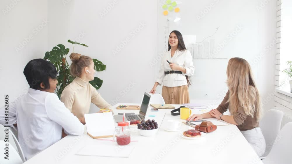 Business people concept. Young woman with blonde hair give presentation to multi-ethnic group of people using flip chart Business people concept. Young woman with blonde hair give presentation to multi-ethnic group of people using flip chart