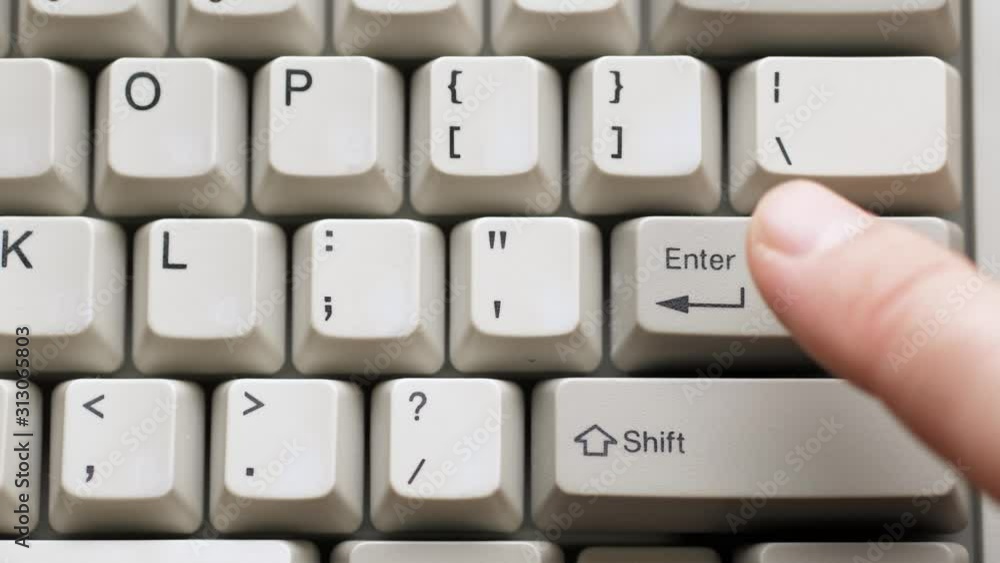 Male finger pushes ENTER button on white keyboard. Slow motion and macro view Male finger pushes ENTER button on white keyboard. Slow motion and macro view