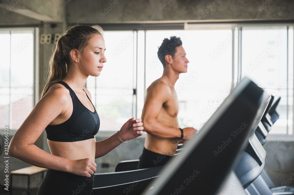 Young couple Exercising by running on the treadmill To maintain good health always Young couple Exercising by running on the treadmill To maintain good health always